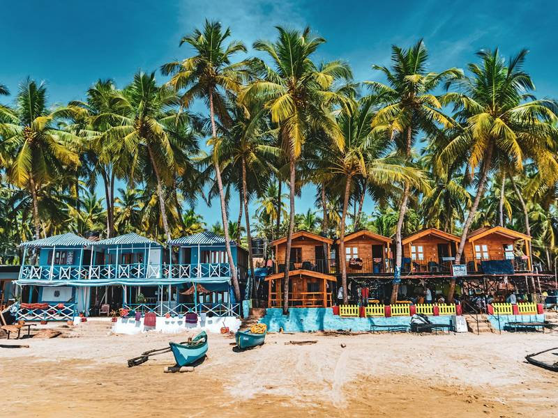 Colourful beach huts under palm trees in Goa
