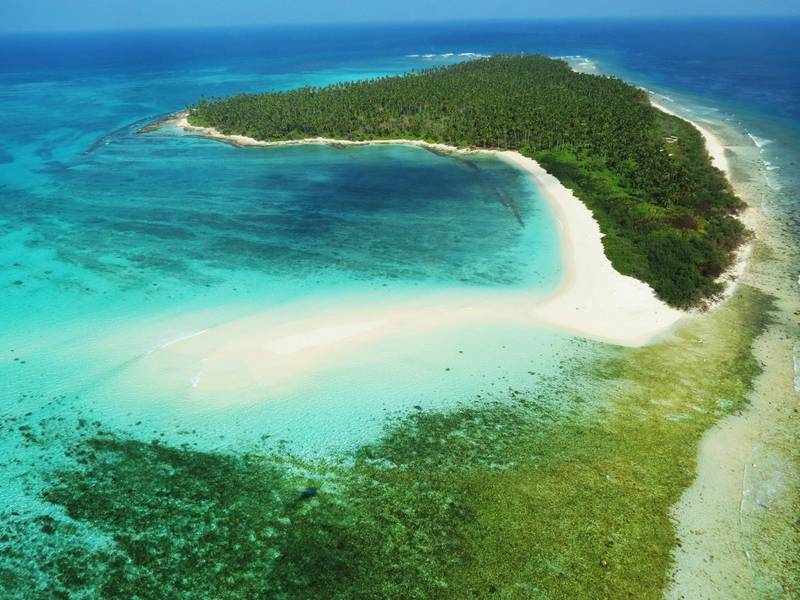 Aerial view of a green island and turquoise lagoon in Lakshadweep