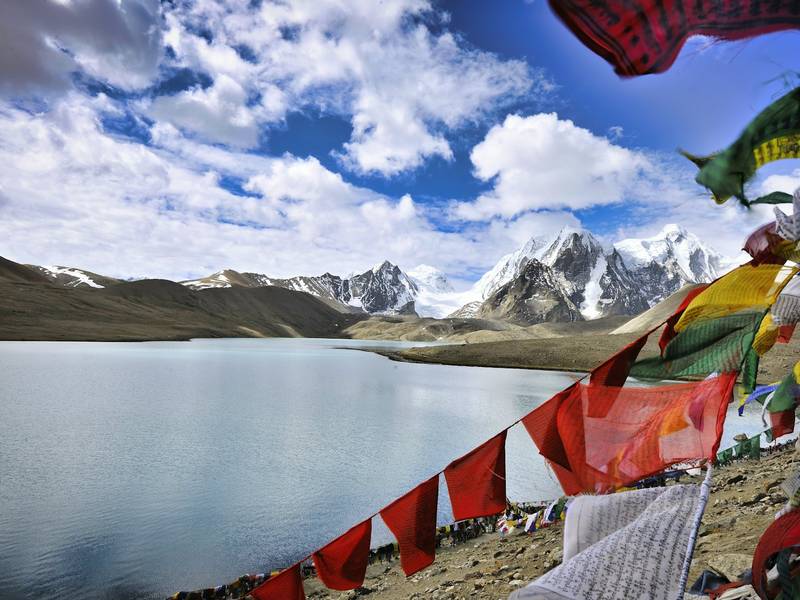 Prayer flags beside a high-altitude lake in Sikkim