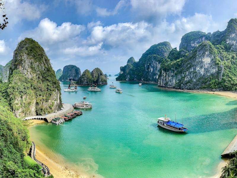 Boats on turquoise water among limestone islands in Ha Long Bay